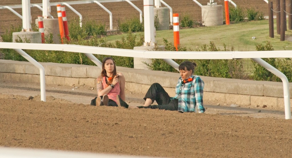 Marley Daviduk and Samantha Baskerville of VADL lock themselves to the inner track railing at the Calgary Stampede Chuckwagon races.